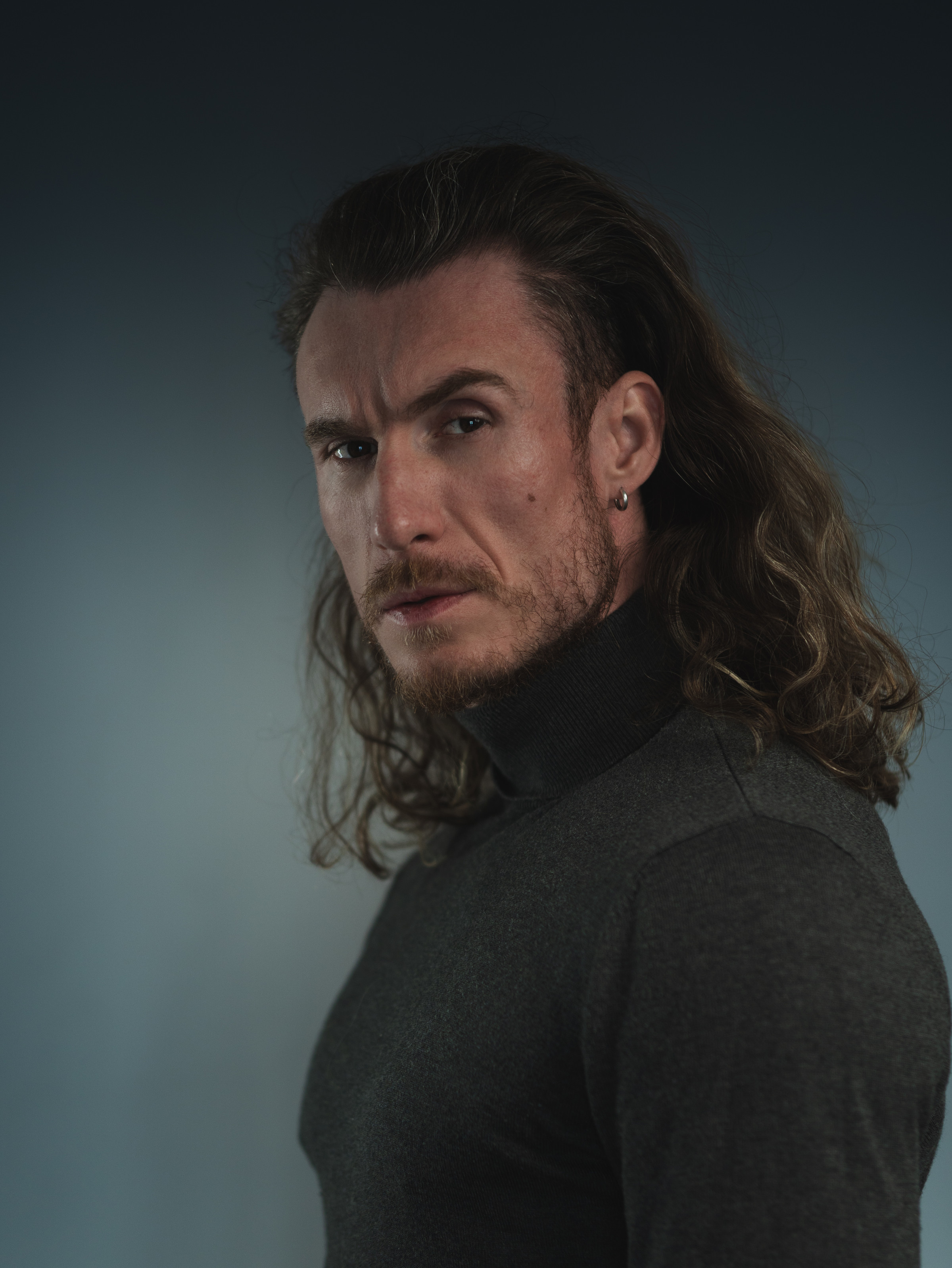Adi Gheo Romanian actor dramatic three-quarter portrait with long hair